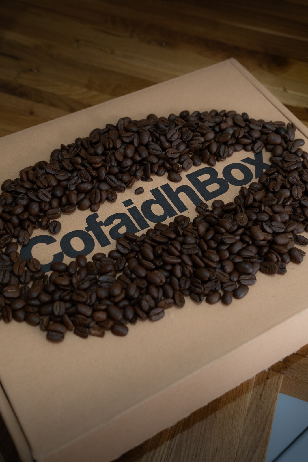 CofaidhBox coffee subscription box surrounded by roasted coffee beans